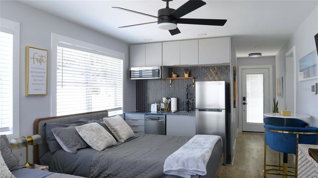 A studio apartment features a bed, kitchenette with stainless steel appliances, and a small dining area — 137 N HOLLYWOOD AVENUE, DAYTONA BEACH, FL