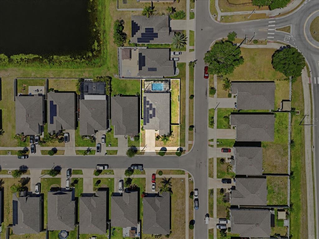 This aerial view shows a residential house with a swimming pool and solar panels — 936 ZONE TAILED HAWK PLACE, RUSKIN, FL