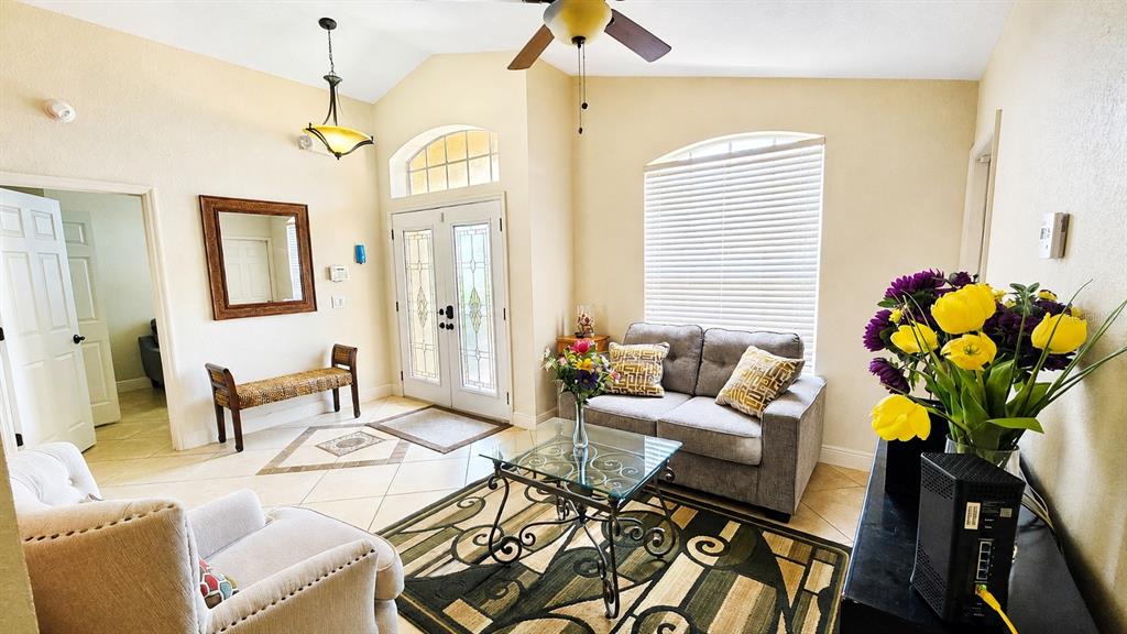 A bright red double front door with glass inserts sits beneath an arched transom window — 148 BELFRY DRIVE, DAVENPORT, FL