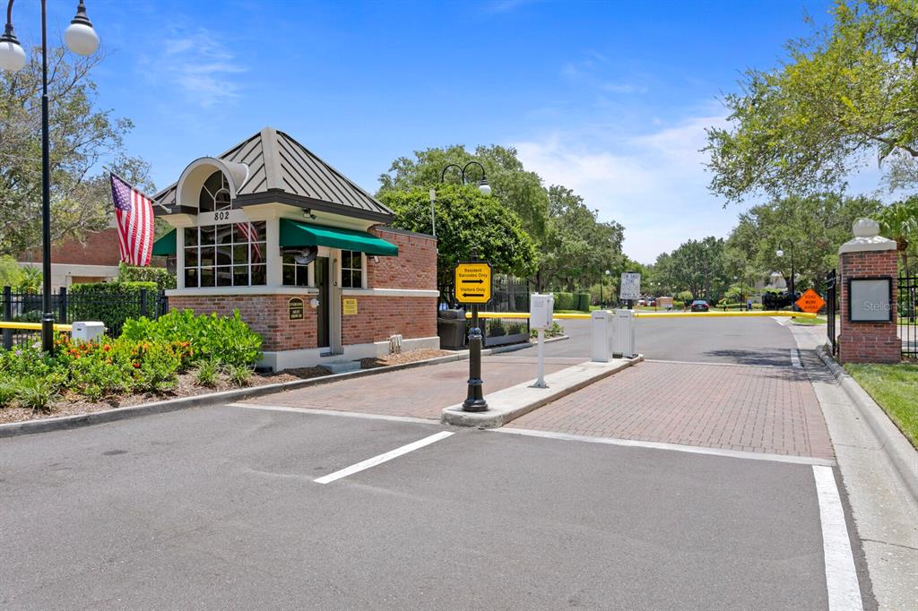 A gated community entrance features a brick guardhouse with a green awning and American flag — 1002 S HARBOUR ISLAND BOULEVARD UNIT 1101, TAMPA, FL