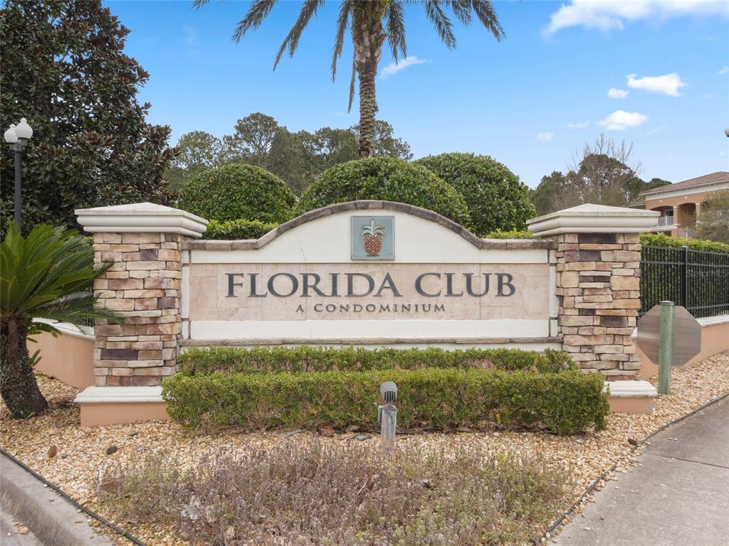 The stone entrance sign for Florida Club A Condominium stands outdoors under a palm tree — 540 FLORIDA CLUB BOULEVARD UNIT 305, ST AUGUSTINE, FL
