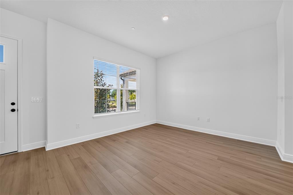 An empty room with white walls, light wood-look flooring, and a window with blinds — 13321 LUSH LIME ALLEY, WINDERMERE, FL