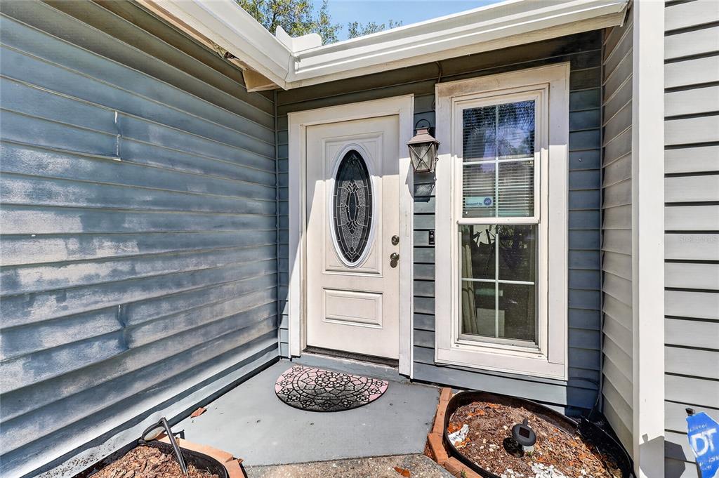 A front entryway with a white door, a single window, and gray horizontal siding — 4646 OLD 37 ROAD, LAKELAND, FL