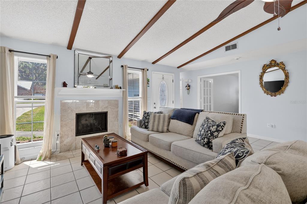 A living room features a tiled floor, a stone fireplace, and a vaulted beamed ceiling — 4646 OLD 37 ROAD, LAKELAND, FL
