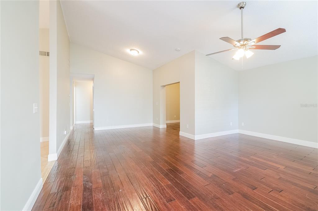 An empty room with hardwood floors, a vaulted ceiling, and a ceiling fan — 1535 LAWNDALE CIRCLE, WINTER PARK, FL