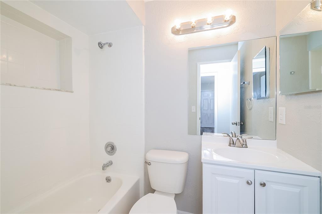 A bathroom featuring a white vanity, a toilet, and a tub-shower combination with white tile — 1535 LAWNDALE CIRCLE, WINTER PARK, FL