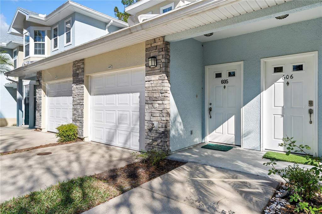 The exterior of a multi-unit residential building features two white front doors and garage doors — 215 BAYBERRY CIRCLE UNIT 605, ST AUGUSTINE, FL