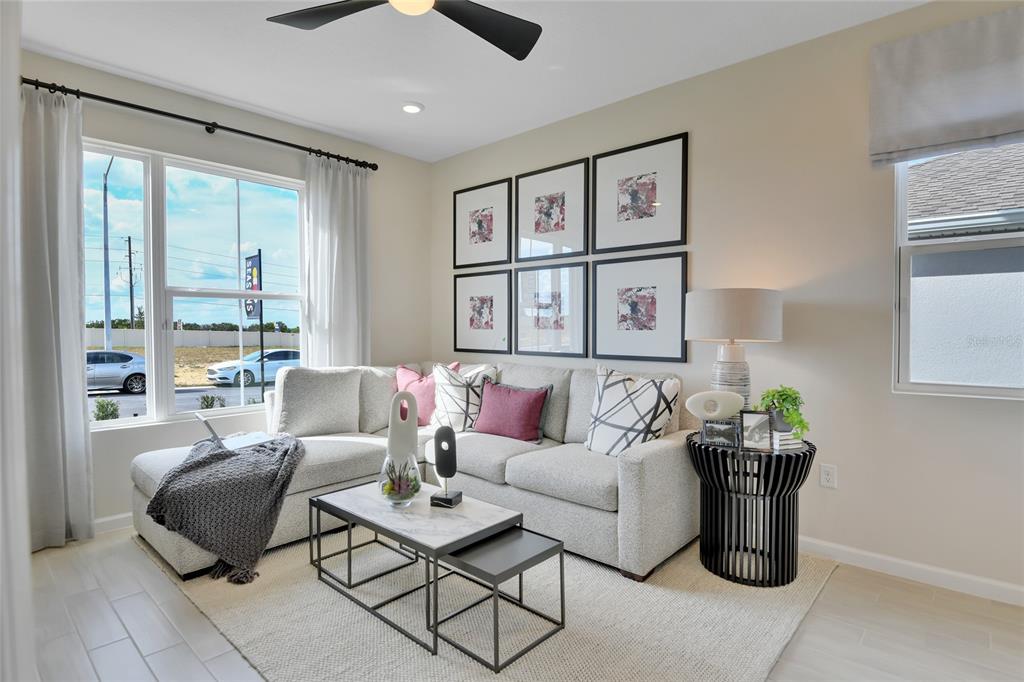 A living room features a sectional sofa, a nested coffee table, and framed wall art — 164 FLAG LILLY LANE, UMATILLA, FL