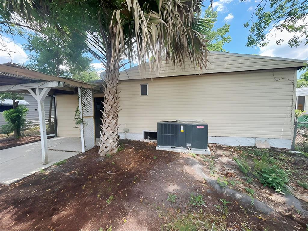 The exterior of a house features beige siding, a palm tree, and an HVAC unit — 170 PALM DRIVE, DEBARY, FL