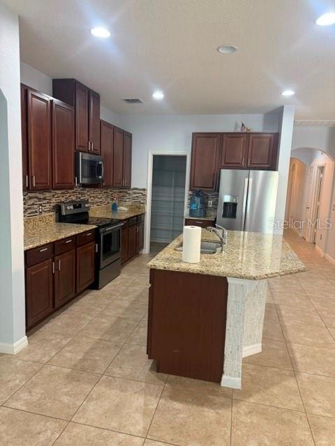 A kitchen features dark wood cabinets, granite countertops, stainless steel appliances, and a central island — 3817 MT VERNON WAY, KISSIMMEE, FL