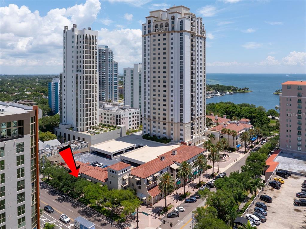 An aerial view shows a low-rise building with a red tile roof near high-rise towers — 300 BEACH DRIVE NE UNIT 309, ST PETERSBURG, FL