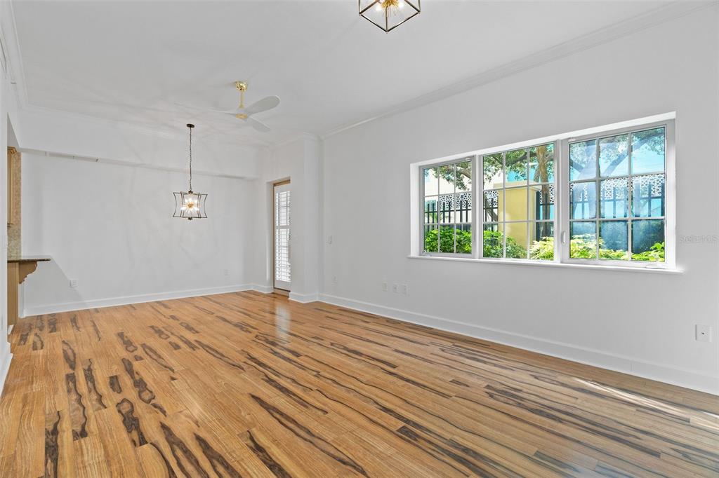 An empty room with hardwood floors, a ceiling fan, a light fixture, and large windows — 300 BEACH DRIVE NE UNIT 309, ST PETERSBURG, FL