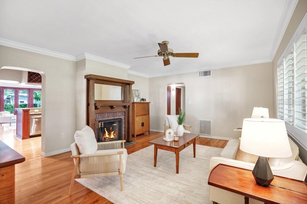 A living room features a brick fireplace, hardwood floors, a ceiling fan, and white walls — 601 WESTMINSTER STREET, ORLANDO, FL