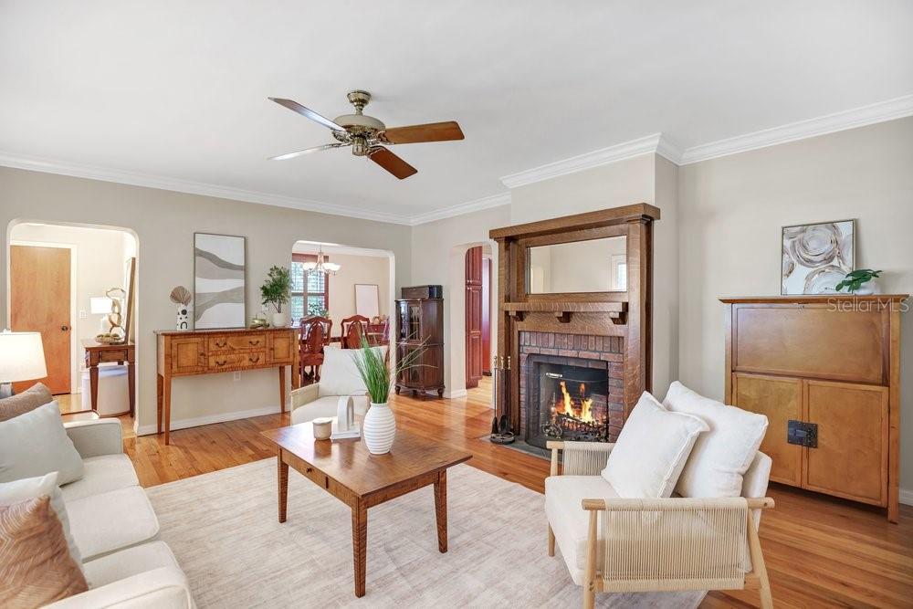 A living room features hardwood floors, a brick fireplace with a wooden mantel, and furniture — 601 WESTMINSTER STREET, ORLANDO, FL
