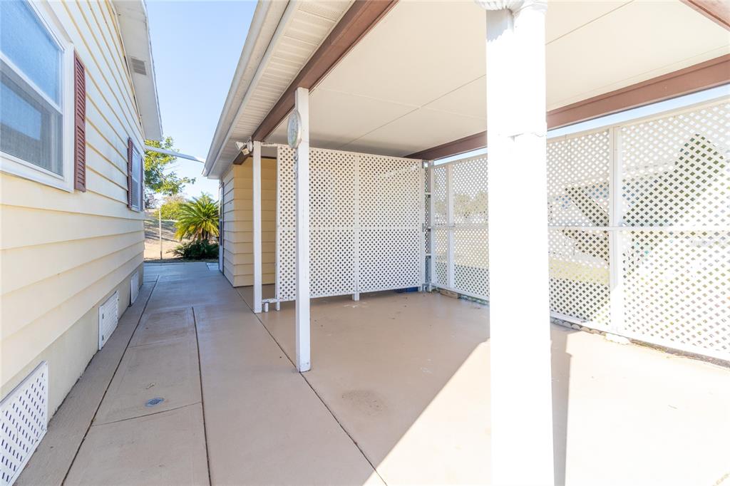 A covered concrete patio area features white lattice privacy screens and support posts — 153 EGRET CIRCLE, ELLENTON, FL
