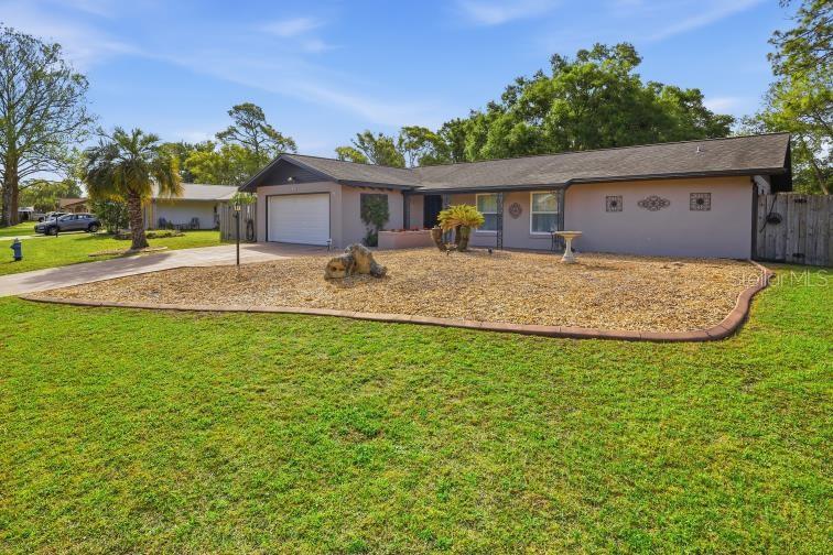 A single-story house with a gravel front yard, a garage, and a palm tree — 60 BLAINE DRIVE, PALM COAST, FL