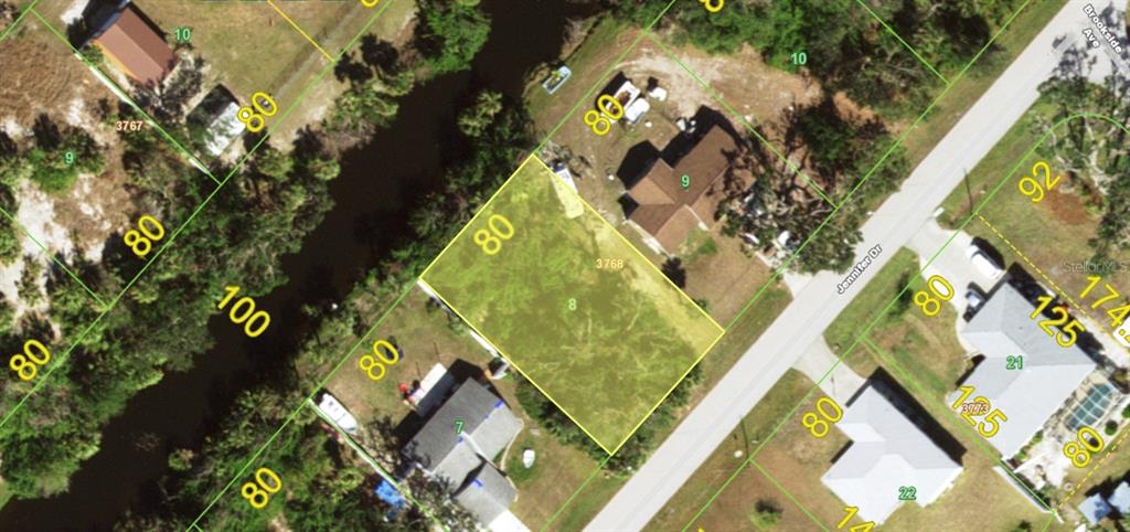 This is an aerial map showing a vacant residential lot highlighted in yellow — 7465 JENNIFER DRIVE, PORT CHARLOTTE, FL
