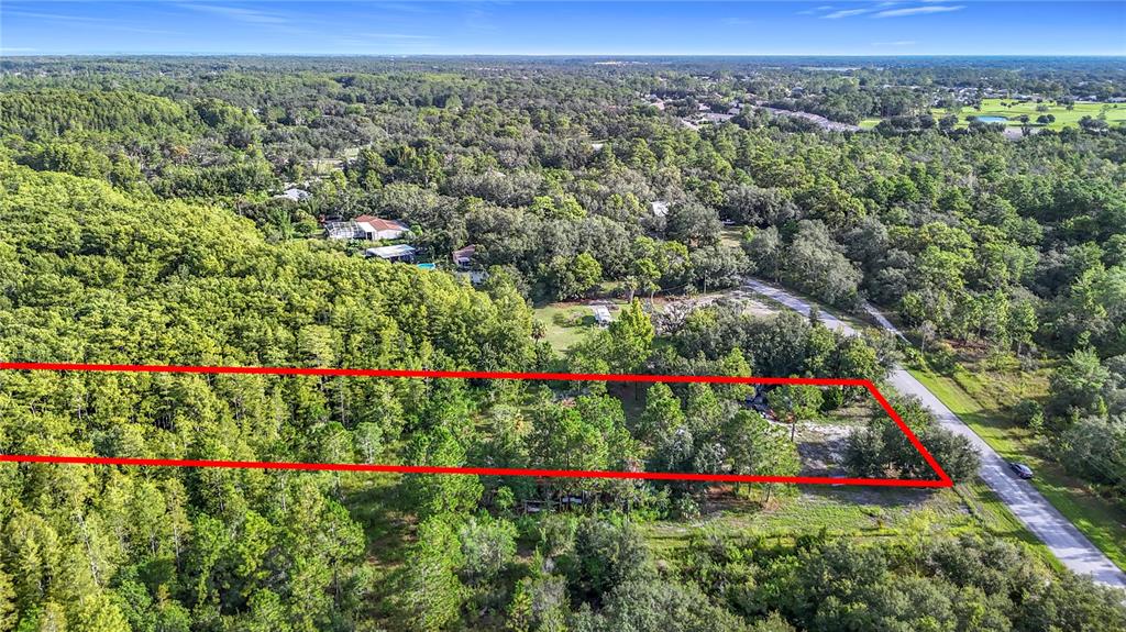An aerial view shows a rectangular plot of land outlined in red next to a road — 0 THOMAS BOULEVARD, HUDSON, FL