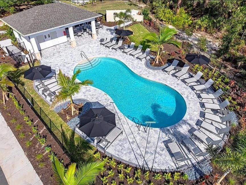 A covered entryway features a dark front door, a single window, and concrete flooring — 7154 GRAND FOREST WAY, NOKOMIS, FL