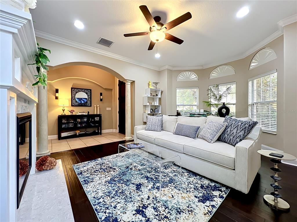 A living room features a white sofa, a blue patterned rug, and a fireplace — 6977 DOLCE STREET, ORLANDO, FL