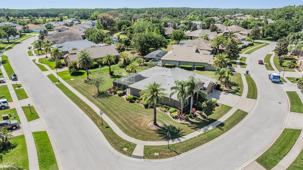 An aerial view shows a suburban house with a screened pool on a corner lot — 8721 CRYSTAL CREEK COURT, LAND O LAKES, FL