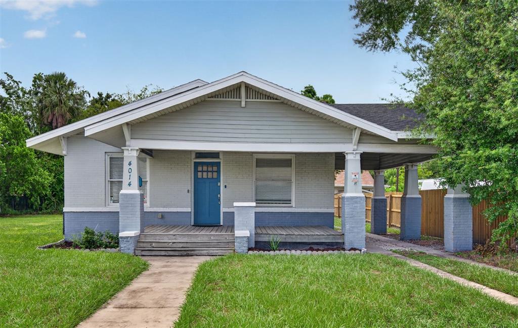 A single-story house with a blue front door, a covered porch, and a carport — 4014 N MARGUERITE STREET, TAMPA, FL