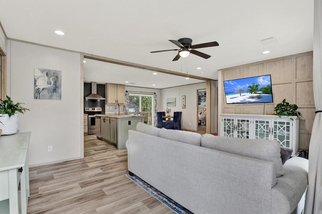 A living room with a grey sofa faces a wall-mounted television and a kitchen island — 2845 N LAKEFRONT DRIVE, HERNANDO, FL