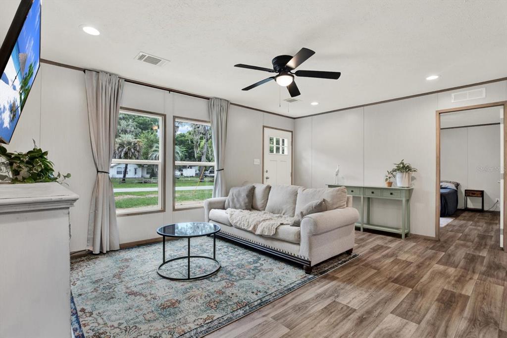 A living room features a sofa, coffee table, area rug, and wood-look flooring — 2845 N LAKEFRONT DRIVE, HERNANDO, FL