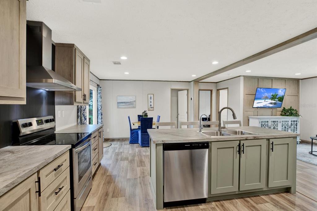 A kitchen features a large island with a stainless steel dishwasher and light-colored cabinetry — 2845 N LAKEFRONT DRIVE, HERNANDO, FL