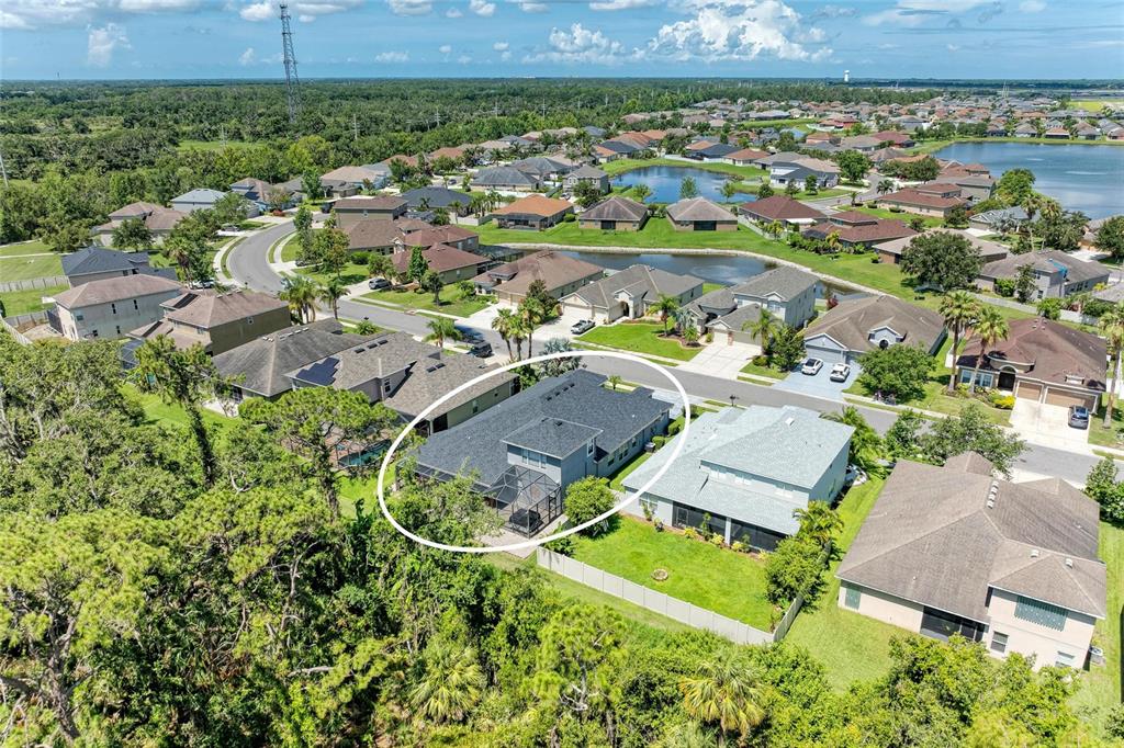 An aerial view shows a gray single-family house with a dark roof and screened patio — 7812 115TH AVENUE E, PARRISH, FL
