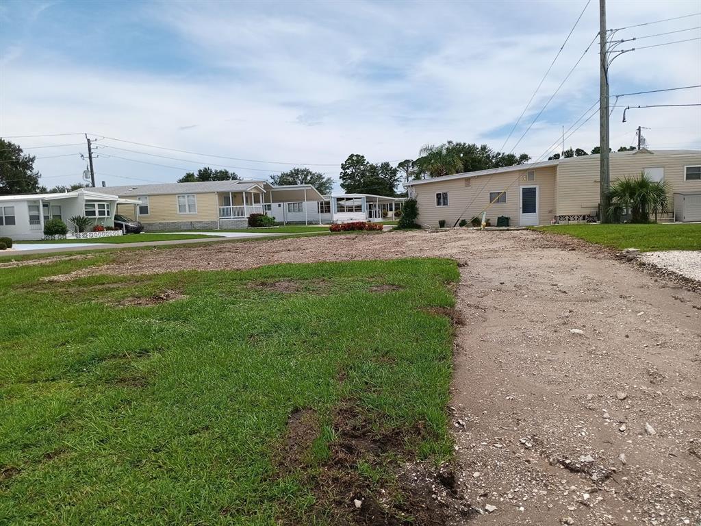 A vacant dirt lot sits in front of several manufactured homes in a residential community — 825 CAREFREE, VENICE, FL