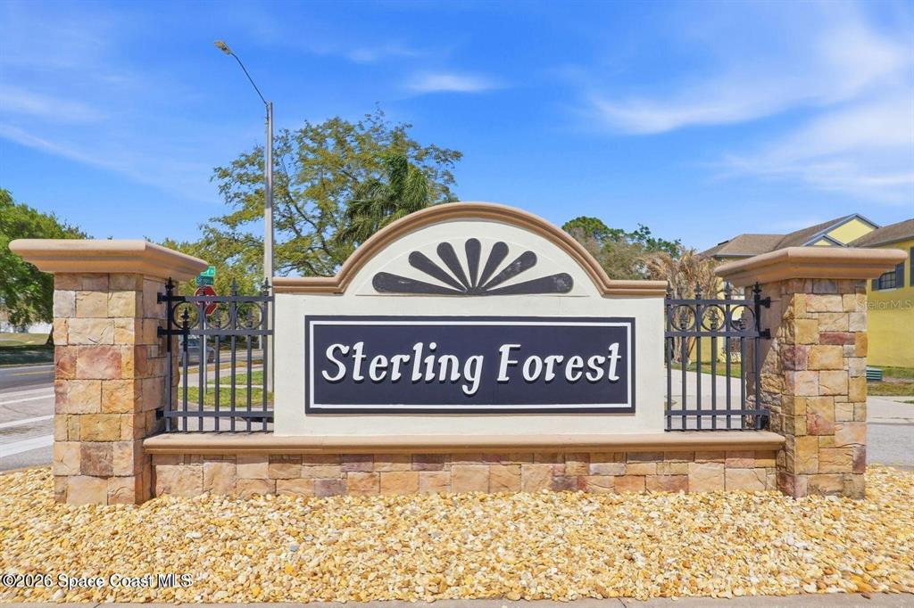 A stone monument sign with black metal fencing marks the entrance to Sterling Forest — 782 MARIAN COURT, TITUSVILLE, FL