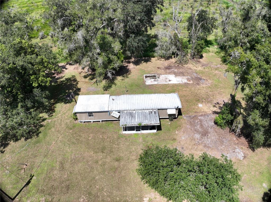 An aerial view shows a mobile home with a metal roof and a concrete slab nearby — 3423 SW KABRICH TERRACE, ARCADIA, FL