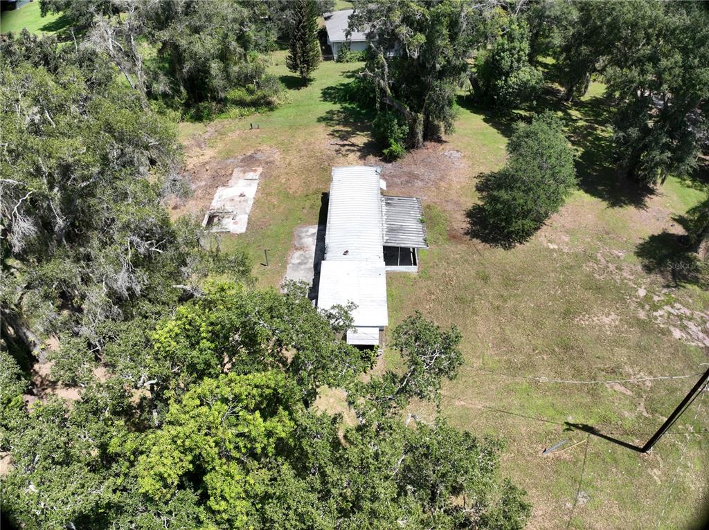 An aerial view shows a mobile home with a metal roof on a wooded lot — 3423 SW KABRICH TERRACE, ARCADIA, FL