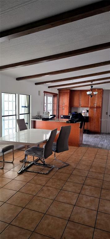 A dining area with a white table and chairs sits before a kitchen with wood cabinets — 14820 COUNTY ROAD 48, ASTATULA, FL