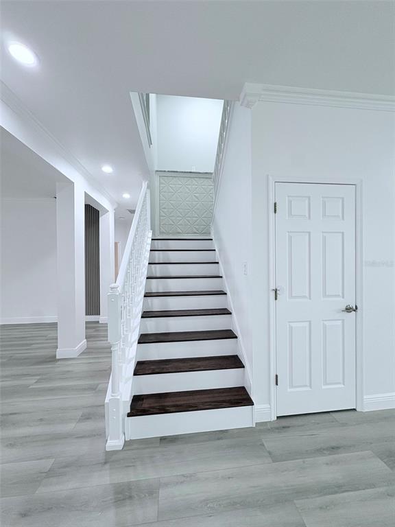 A staircase with dark wood treads and white risers sits beside a white interior door — 2157 WINTERMERE POINTE DRIVE, WINTER GARDEN, FL