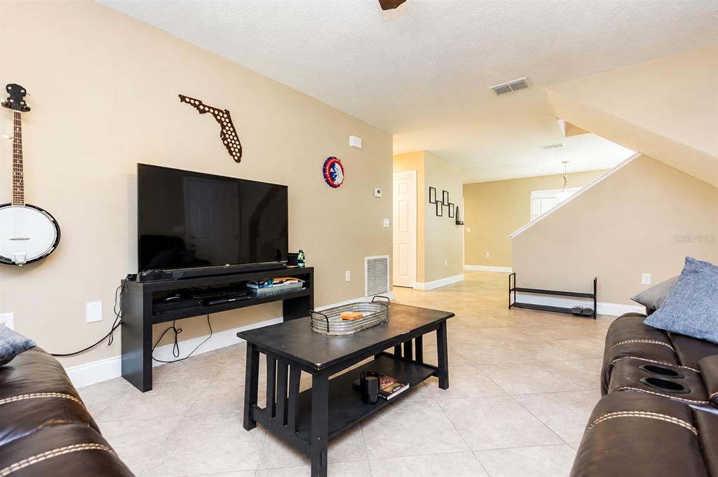 A kitchen features white cabinets, stainless steel appliances, gray countertops, and a subway tile backsplash — 7504 GADSDEN DRIVE, TAMPA, FL