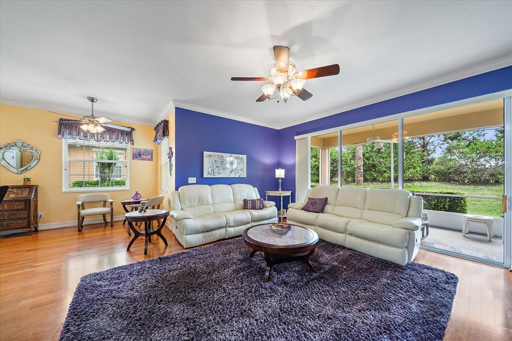A living room features a purple accent wall, two white sofas, and a large area rug — 11547 52ND COURT E, PARRISH, FL