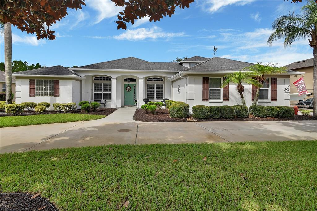 A single-story house with a light-colored exterior, a teal front door, and a concrete driveway — 105 PINE SIDE DRIVE, DEBARY, FL