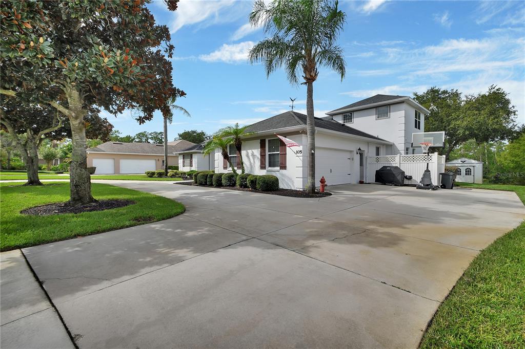 A white house with a two-car garage, a basketball hoop, and a concrete driveway — 105 PINE SIDE DRIVE, DEBARY, FL