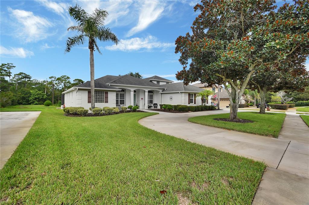 A single-story house with a palm tree, a concrete driveway, and a large front lawn — 105 PINE SIDE DRIVE, DEBARY, FL