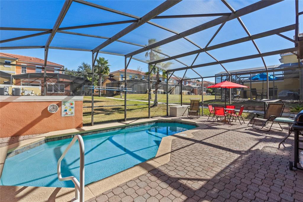 A screened-in patio features a swimming pool, brick pavers, and outdoor furniture — 8535 BAY LILLY LOOP, KISSIMMEE, FL