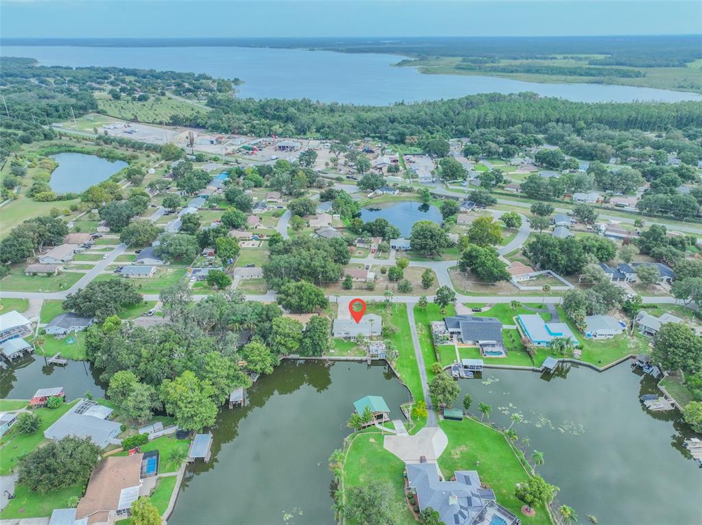 An aerial view shows a house with a red location pin beside a canal — 2712 GRAND ISLAND SHORES ROAD, EUSTIS, FL