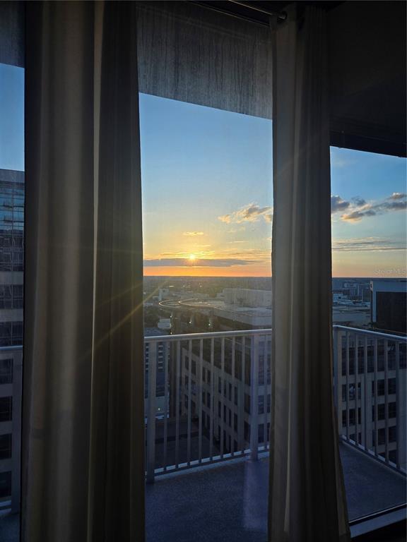 A kitchen with wood cabinets, granite countertops, and a balcony overlooking a city skyline — 155 S COURT AVENUE UNIT 2008, ORLANDO, FL