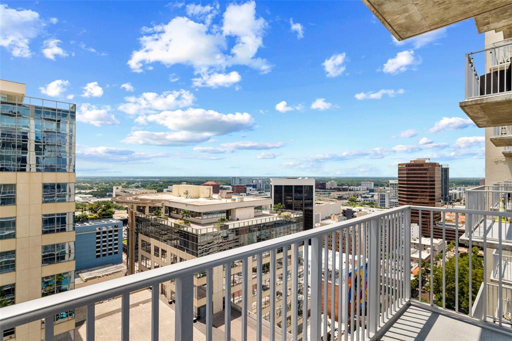 A kitchen with wood cabinets, granite countertops, stainless steel appliances, and floor-to-ceiling windows — 155 S COURT AVENUE UNIT 2008, ORLANDO, FL
