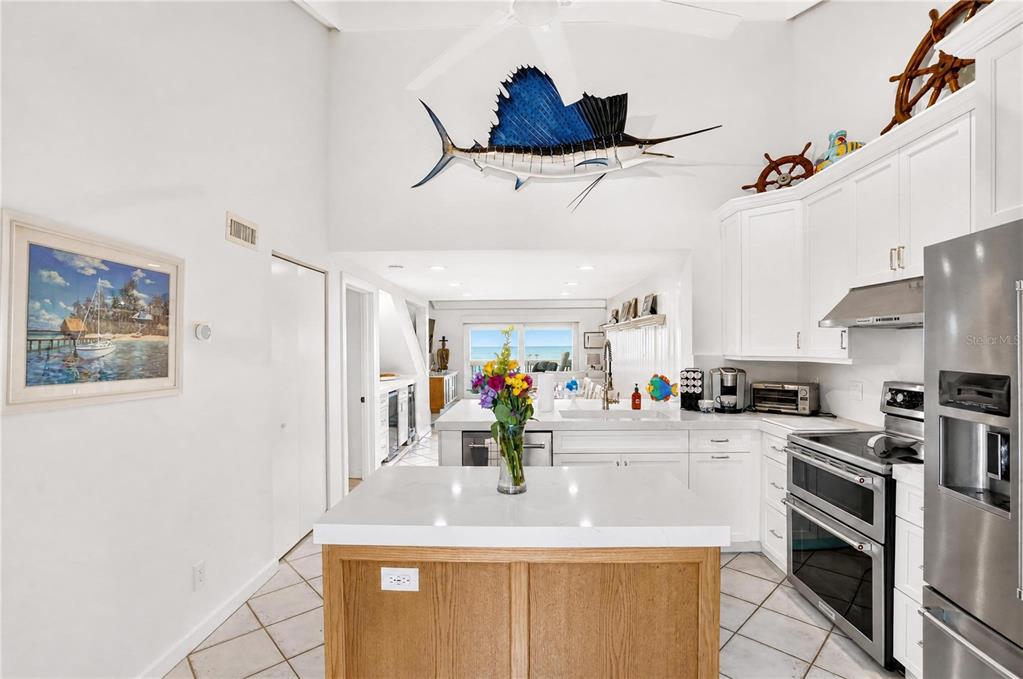 A kitchen with white cabinets, a wooden island, and a large sailfish wall mount — 5275 GULF OF MEXICO DRIVE UNIT 202, LONGBOAT KEY, FL