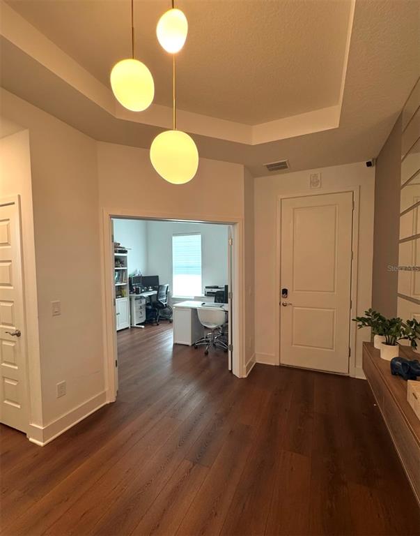 A foyer with wood floors leads into a home office through double doors — 14931 LEBEAU LOOP, WINTER GARDEN, FL