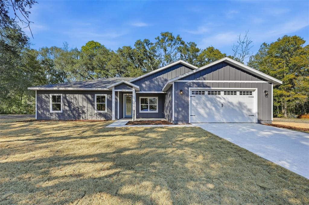 A single-story house with dark gray vertical siding and a two-car garage — TBD SW 170TH STREET, ARCHER, FL