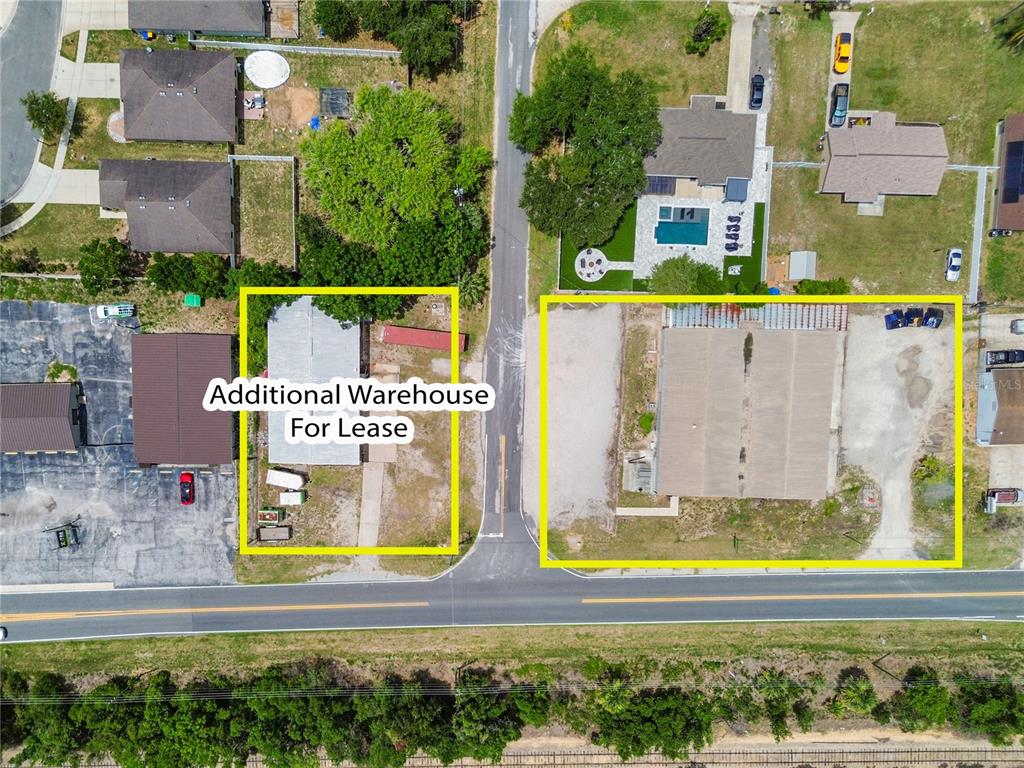 This aerial view shows two commercial properties with warehouses located on opposite sides of a road — 15617 OLD US HIGHWAY 441, TAVARES, FL