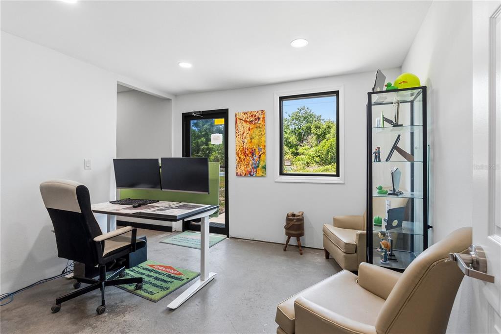 A home office features a standing desk with dual monitors, two armchairs, and a display cabinet — 15617 OLD US HIGHWAY 441, TAVARES, FL